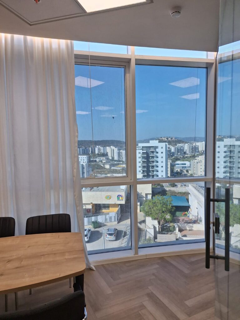 מדבקות אנטיסאן השוואה בין חלון עם מדבקת אנטיסאן וחלון ללא מדבקה, מדגימה את ההבדל בהפחתת הסנוור